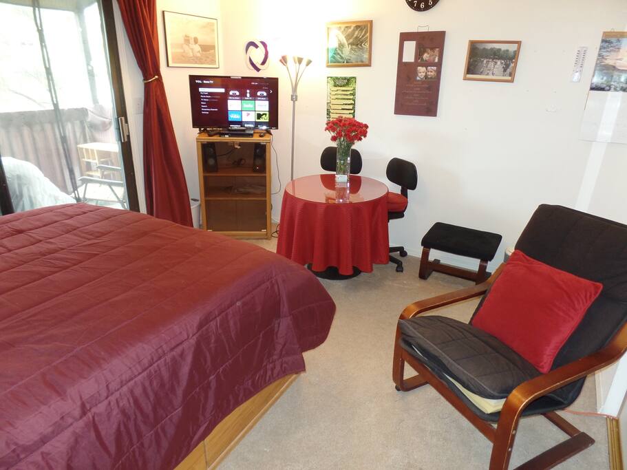 Cable TV with DVD player and Netflix; small work table/dining table for two and lounge chair.