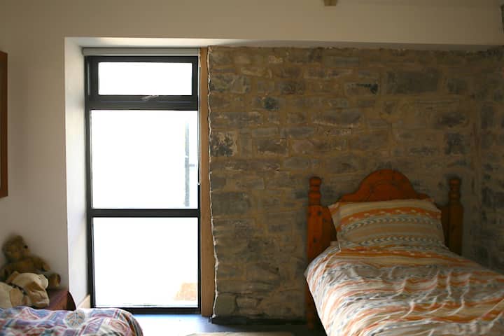 Spavaća soba s 2 odvojena kreveta s pogledom na dvorište