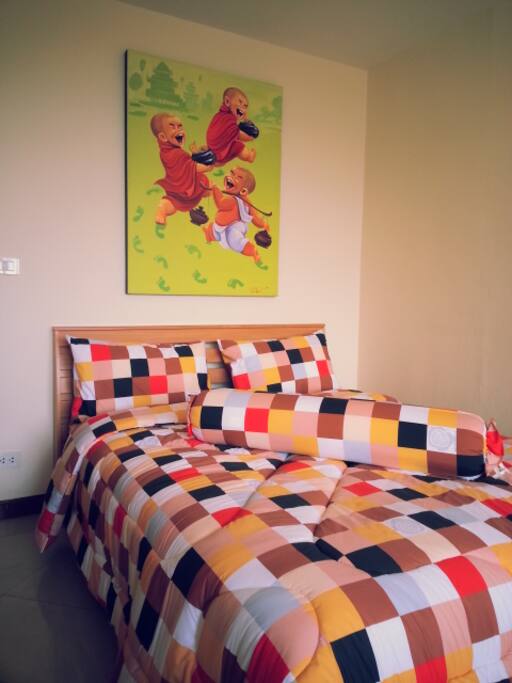Comfortable Queen sized bed with a quilt and or a top sheet.