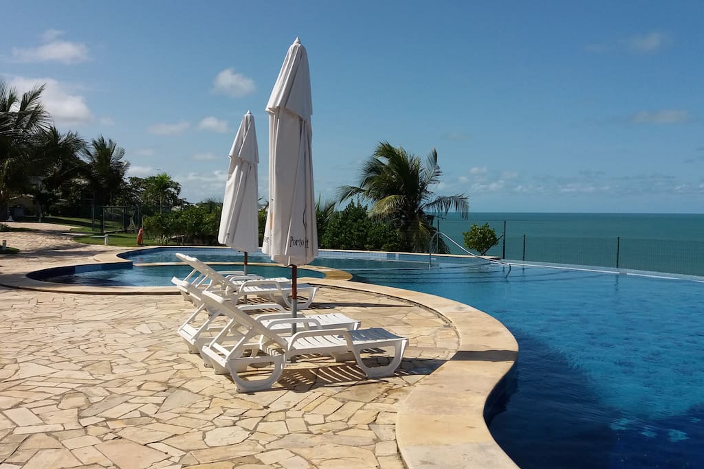 Área de lazer com piscina de borda infinita.