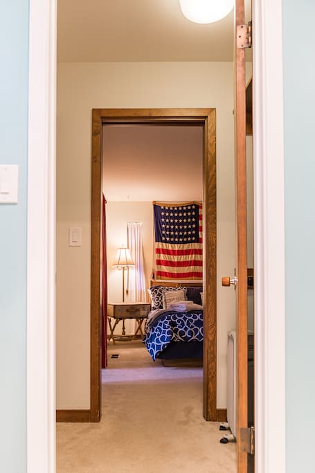 Looking from private bathroom into private bedroom. Fan, heater, and extra linens are to the right.