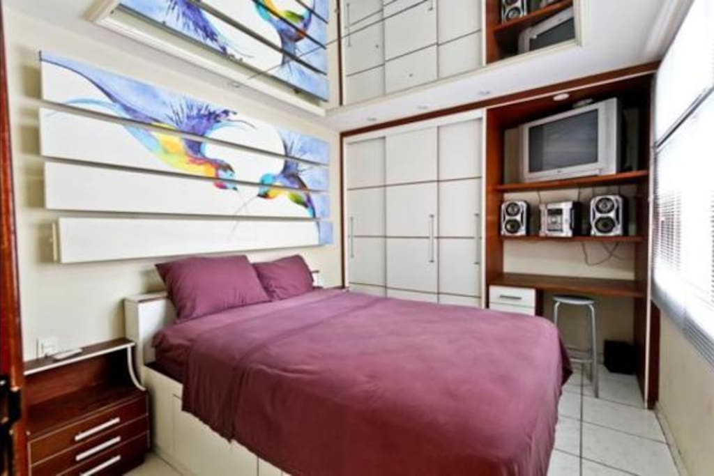 Beautiful bedroom with cozy bed and ceiling mirror