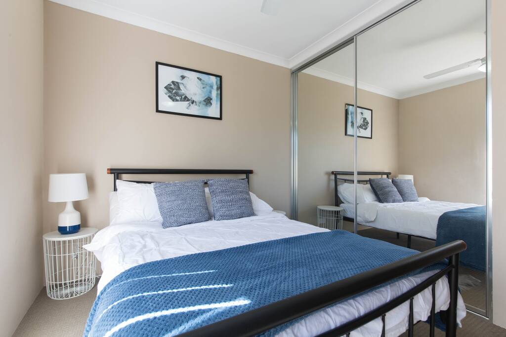 Comfy Double bed in a spacious room with cupboard space and ceiling fan.