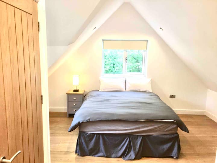 Dormitorio principal con cama tamaño king, armarios empotrados y baño privado con ducha y lavabo. 