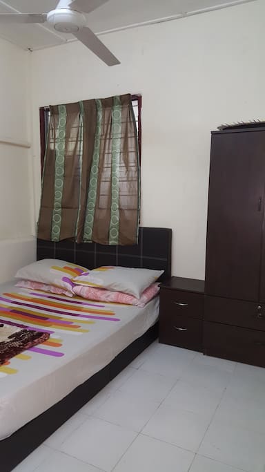 The srcond bedroom with queen bed, side-table and cupboard
