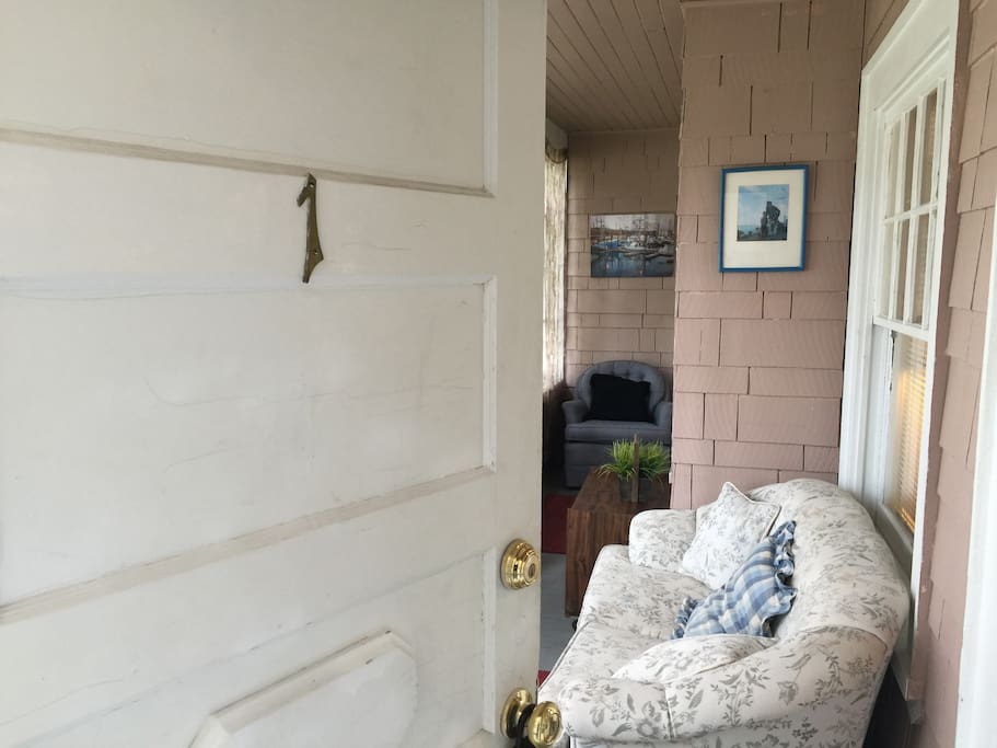 Front door of apartment leads to the enclosed front porch.