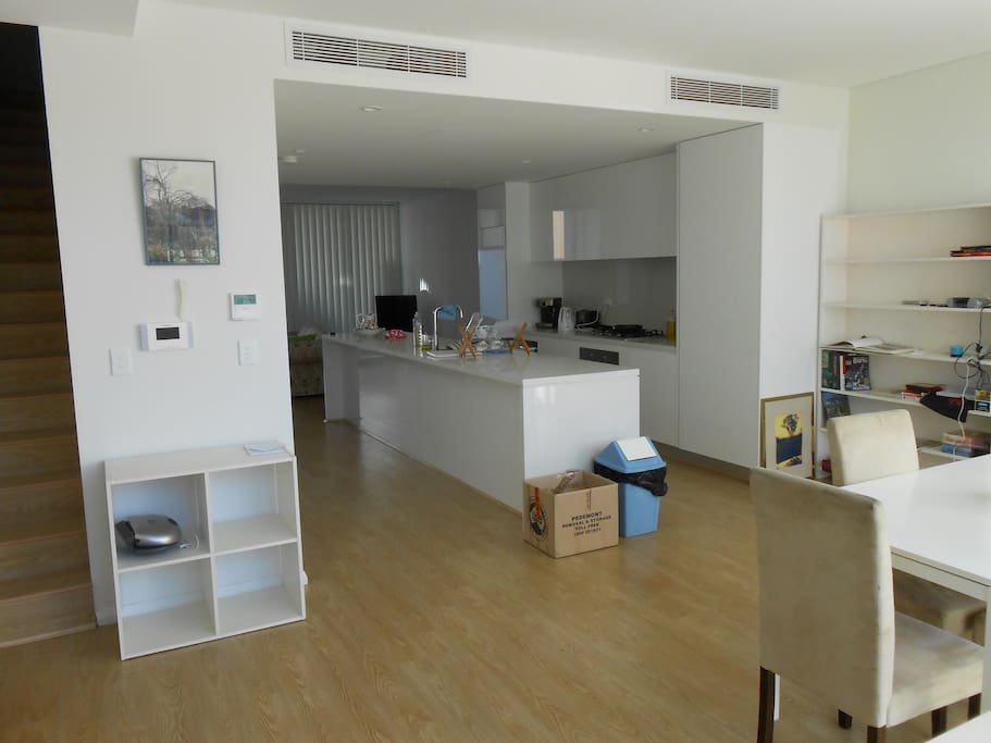 Dining/entrance with kitchen island bench. Stairs up to bedrooms on left. You get full use of kitchen + laundry