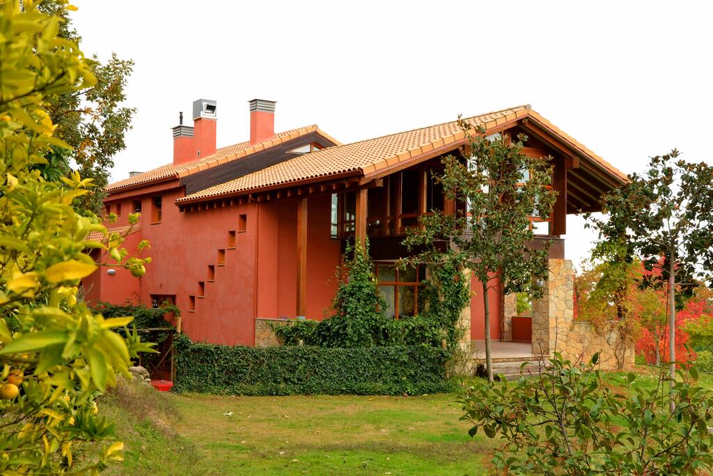 Vista frontal de la casa, alrededor árboles frutales