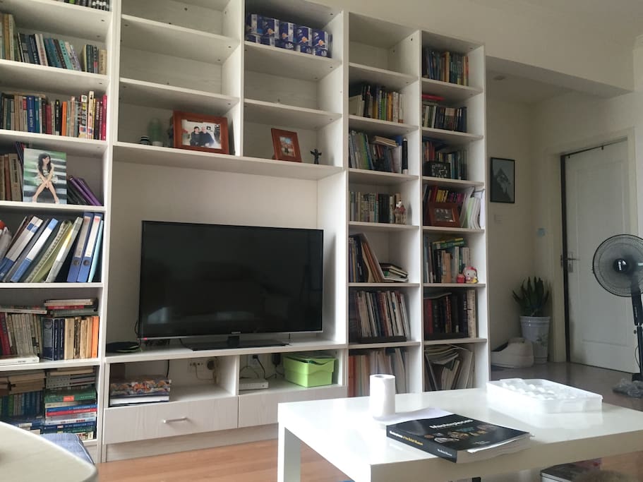 the living room with a shelf and a tv