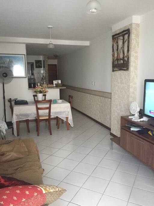 Sala com mesa e 4 cadeiras, 1 sofá-cama, televisão de 40 polegadas.