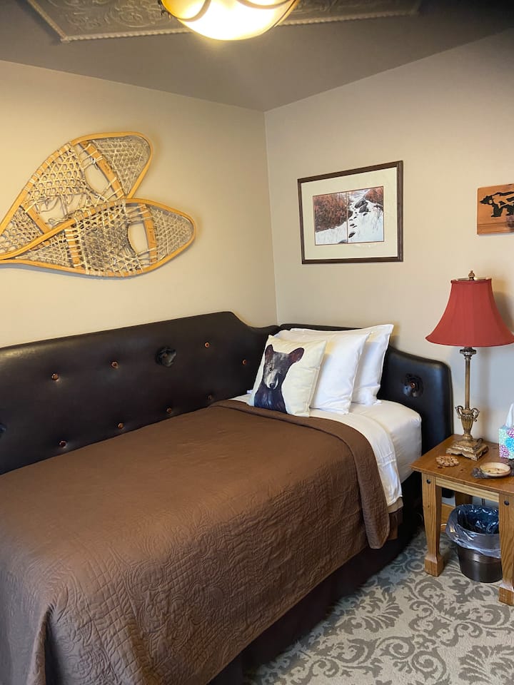 غرفة "الدب". سرير مزدوج الحجم، مكتب صغير، خزانة، رفوف كتب، مرآة.