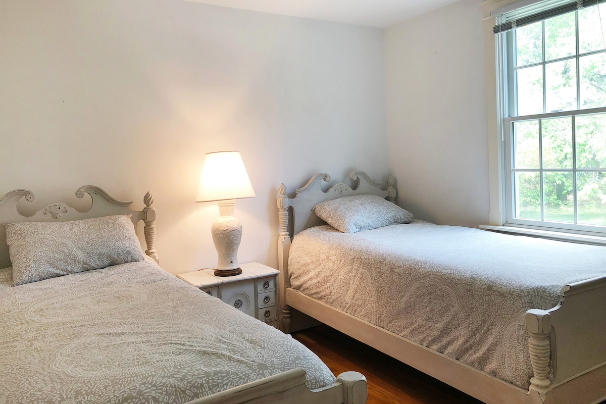 Chambre avec lits jumeaux, placard et commode. 