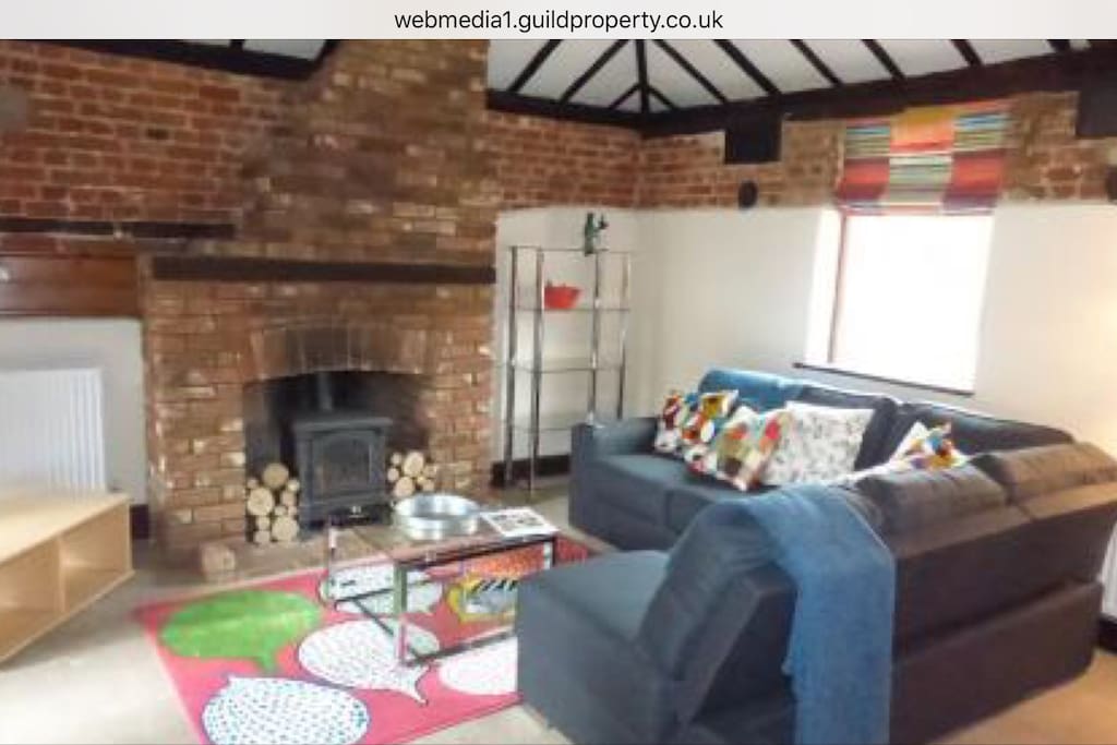Cosy gas stove in brick hearth.