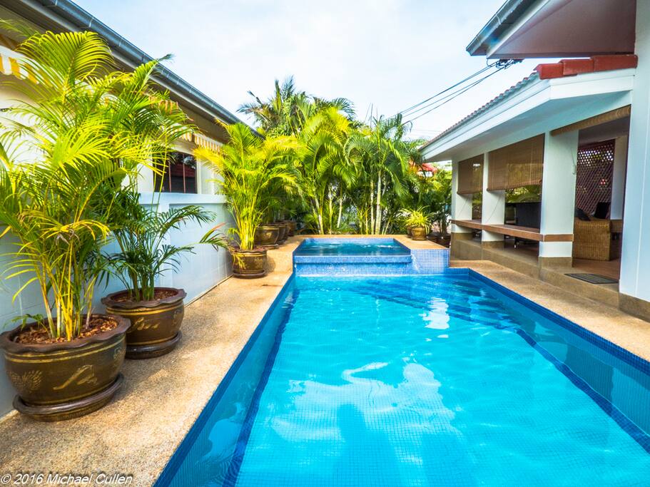 Pool and jacuzzi running along the side of the house