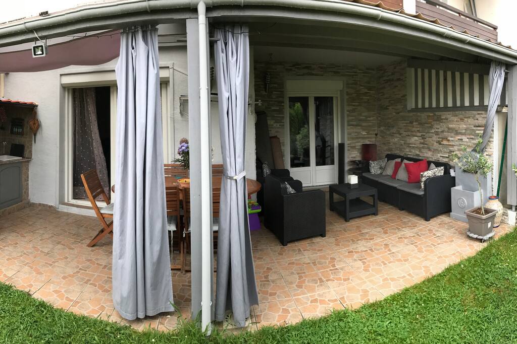Terrasse équipe d'un petit salon pour se détendre, d'une table pour manger paisiblement et d'un coin cuisine pour une plancha !
