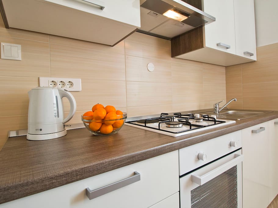 Kitchen contains microwave oven, refrigerator, stove (oven), sink with hot and cold running water, coffe maker, coffe, tea, toster...