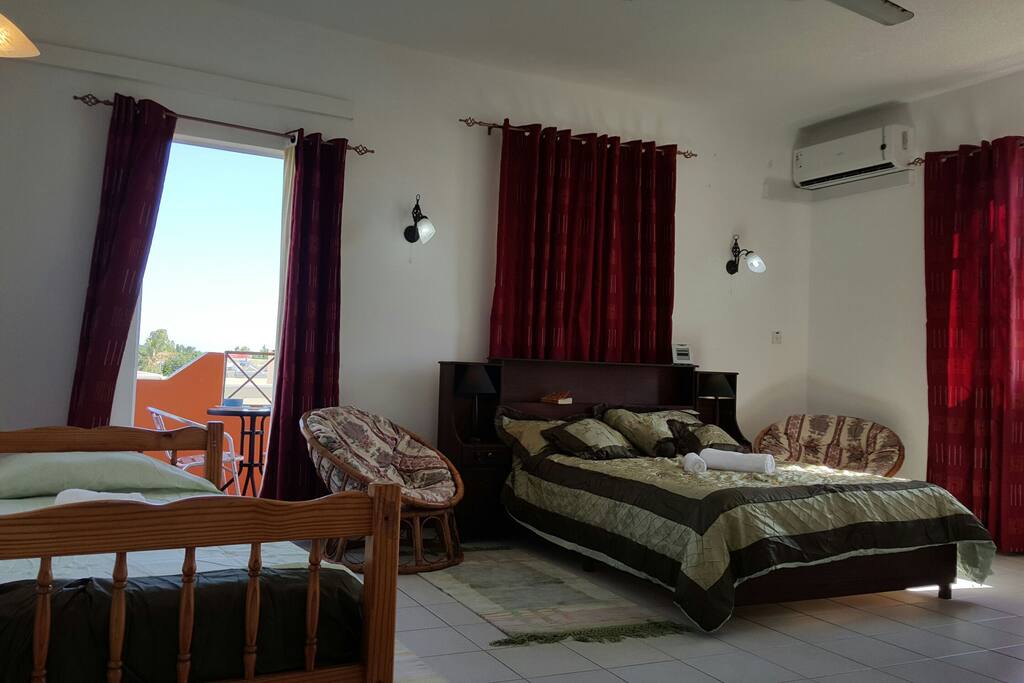 Bedroom with a double bed and a single bed with a balcony and ensuite