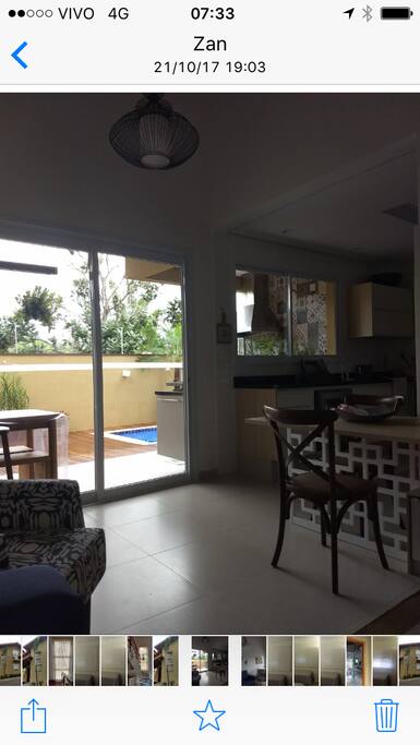 Sala e cozinha americana com vista da piscina e churrasqueira