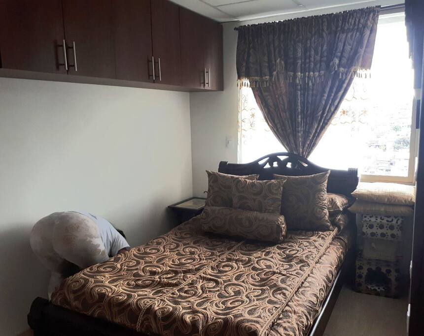 amplia habitación de huéspedes aseada, iluminada y ventilada con closet y televisión