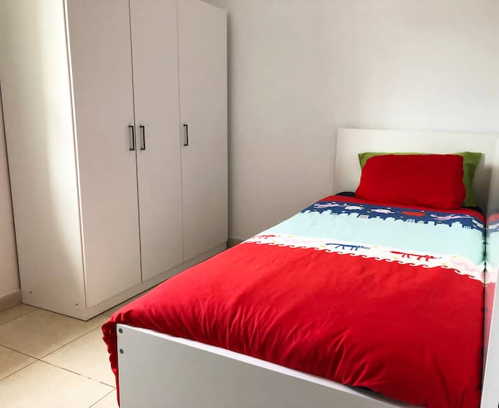 Sovrum med två enkelsängar, med fönster med havsutsikt.