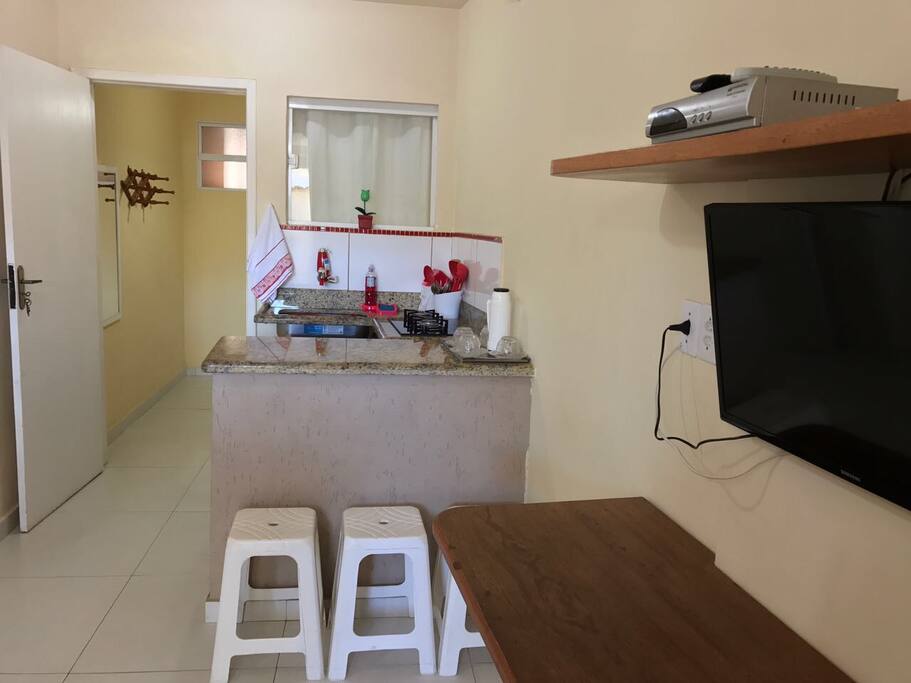Painel com TV com canais abertos e bancada.