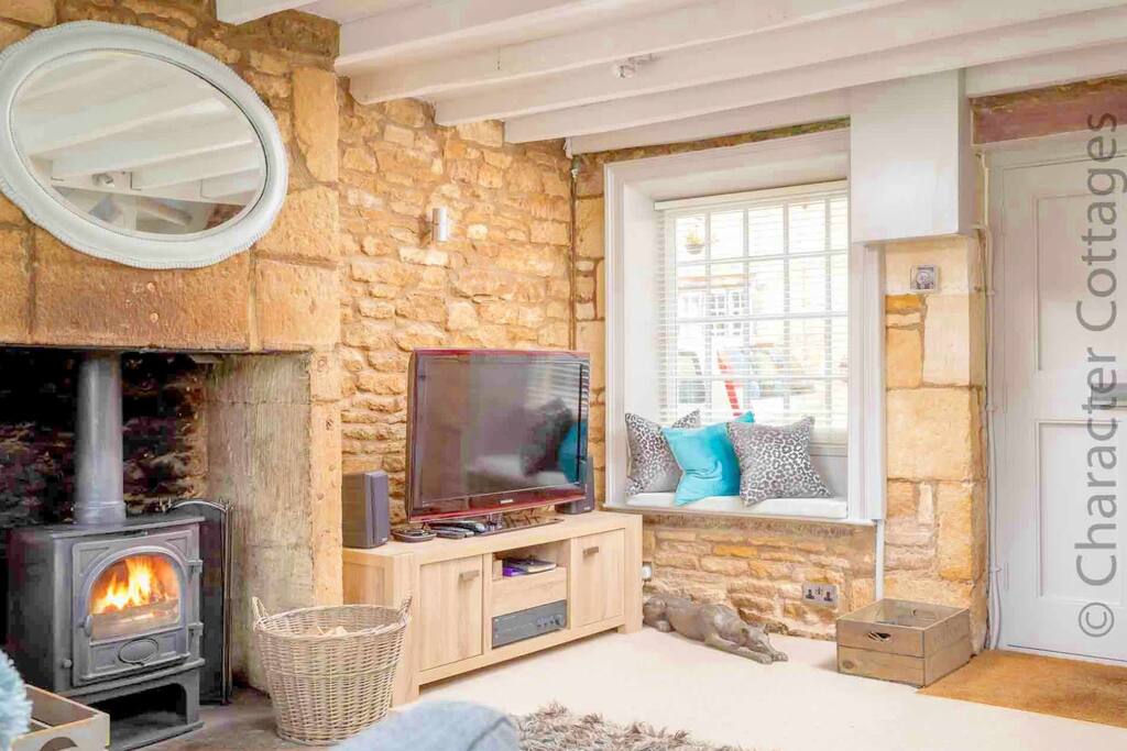 The lovely living room contains a large fireplace, with a lovely wood burning stove