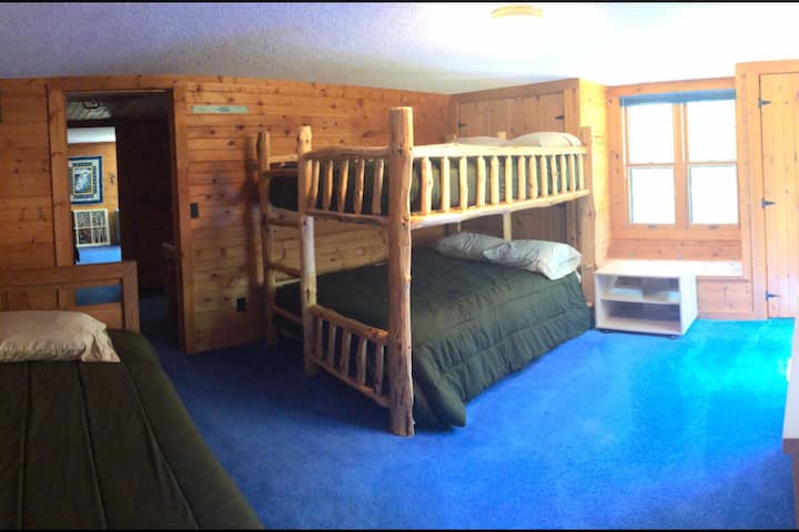 Second floor bedroom with queen log bunk beds and a twin bed mirrors the other bedroom