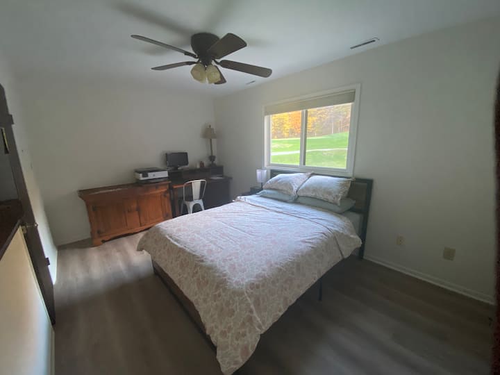 Спална соба на главниот кат со брачен кревет (широк 150-179 см) и простор за работа.