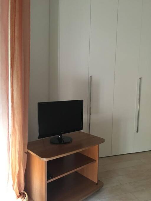 Vista in proiezione della camera da letto con armadio e TV