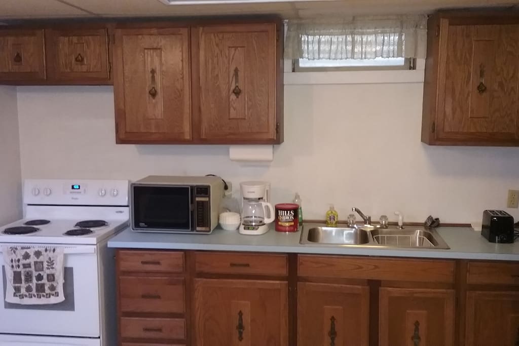 Spacious kitchen which has a stove, refrigerator, microwave, coffee maker, toaster, and kitchenware for your using pleasure.