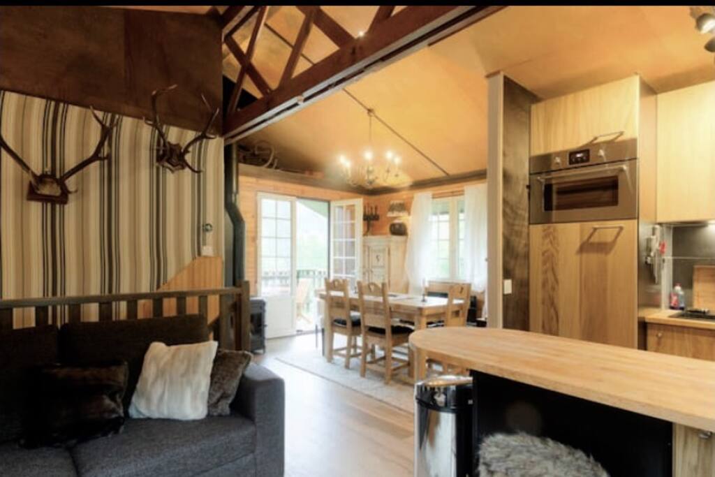 Grande pièce à vivre avec décoration montagne, cuisine américaine et bar