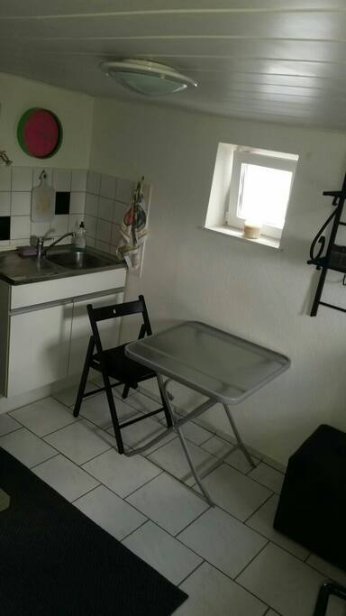 Küche mit Waschschrank und kleiner Sitzgelegenheit
