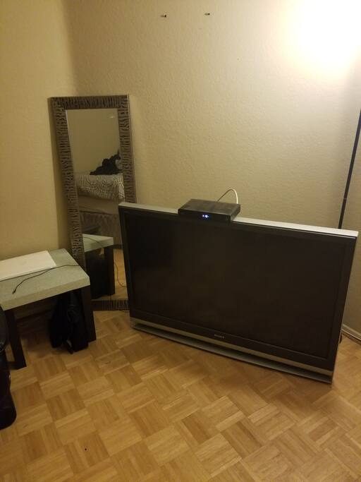 50inch TV. Cable. Mirror. Small table with charging cords.