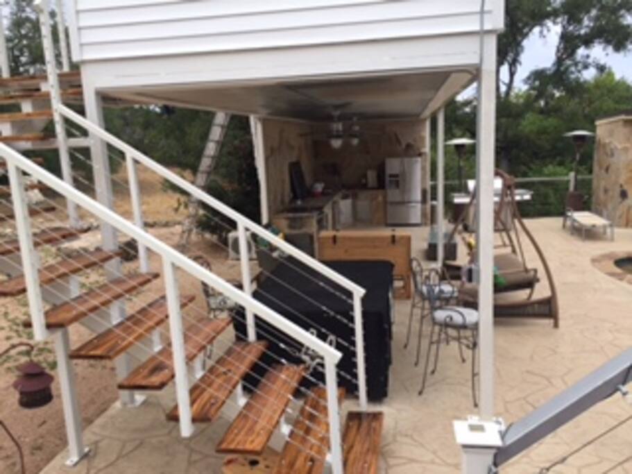 Covered outdoor kitchen and living area with fire pit.