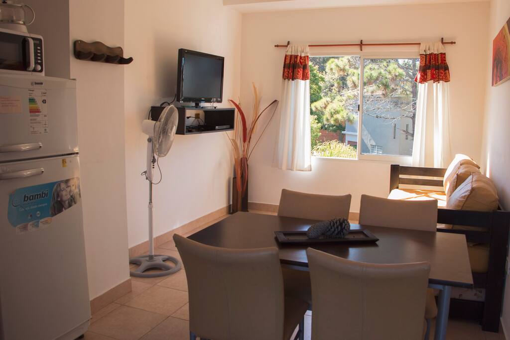 Departamento de 2 ambientes con estar comedor, conectado a la cocina y con vista al jardín central y la pileta climatizada.