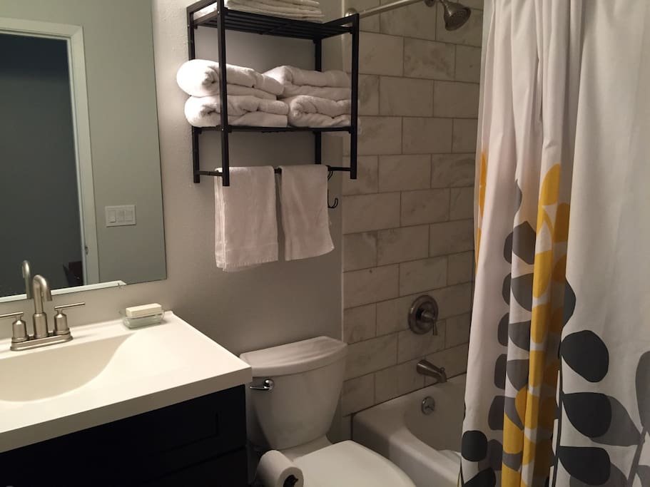 Private bathroom with granite tile shower, towels, other amenities.