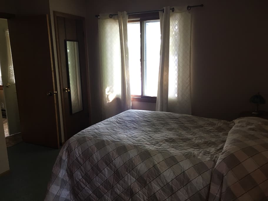 Far bedroom with double bed and view of lake.