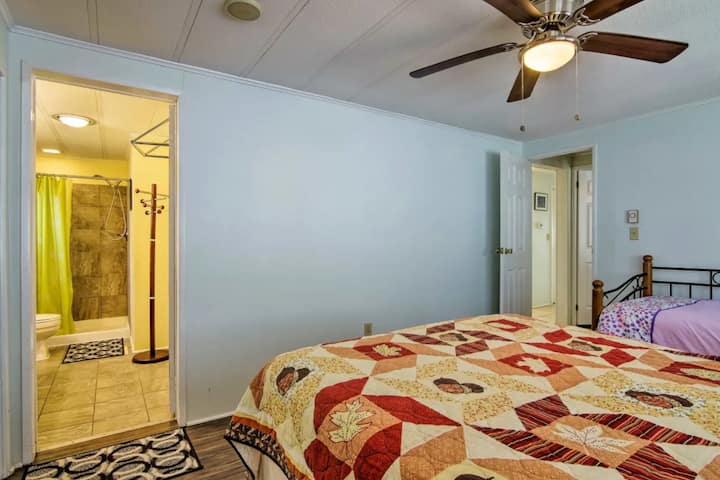 Dhomë gjumi kryesore me krevat të vjetër dhe pamje nga banja