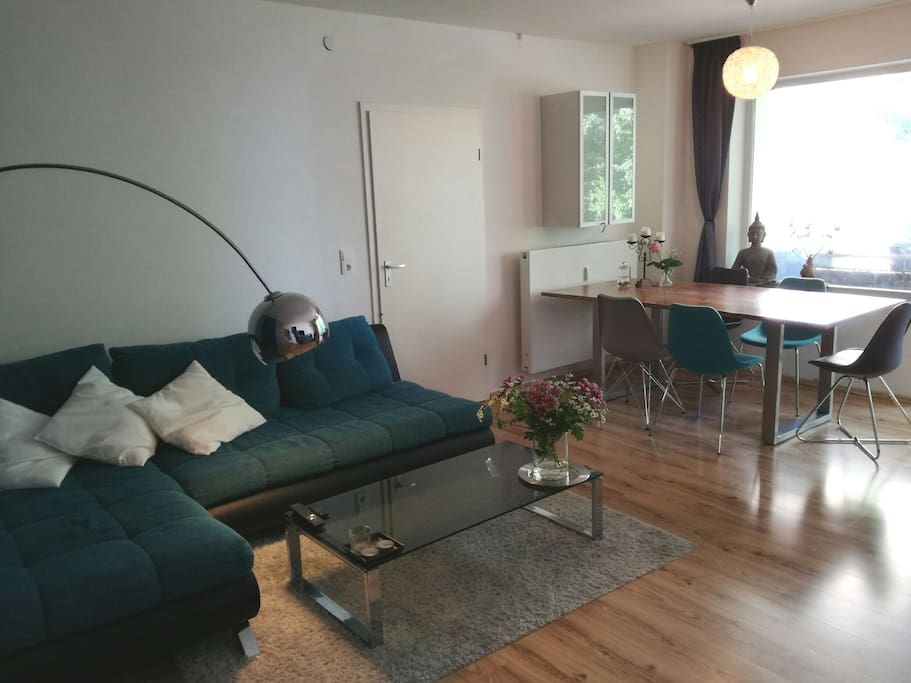 Das Wohnzimmer mit Couch und großem Esstisch.