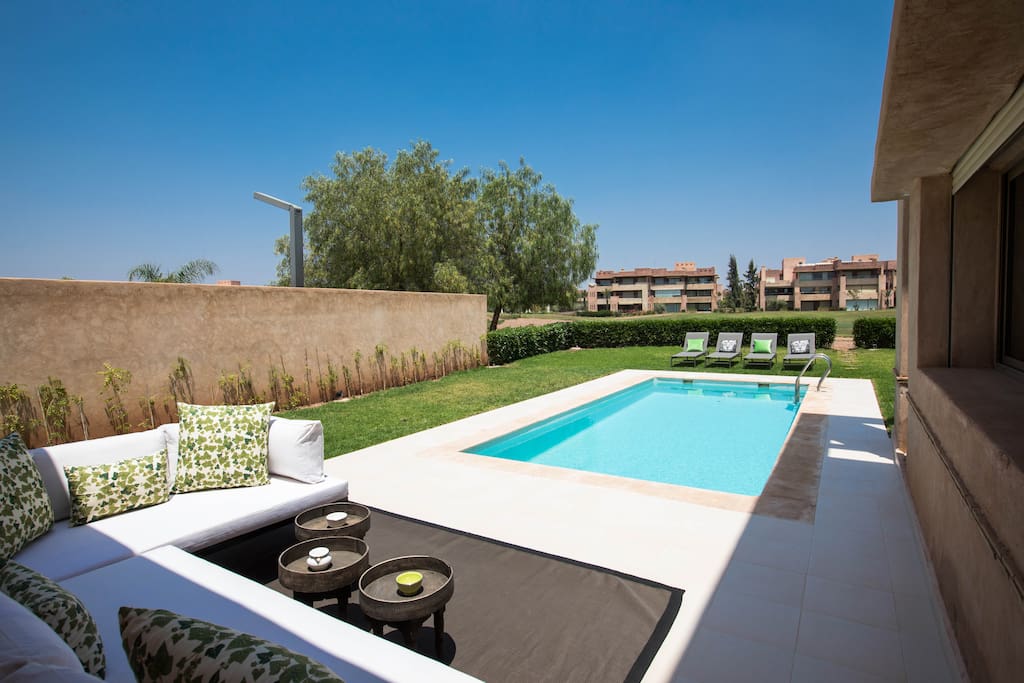view of the pool and the golf course from the lounging area. Direct access to the golf course from the garden.