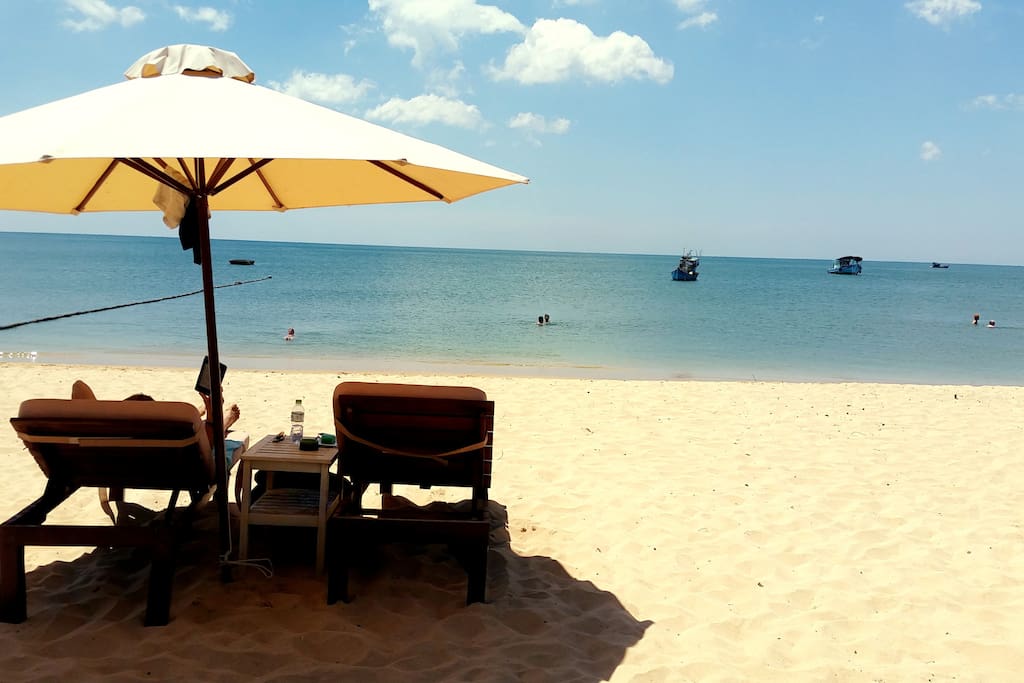 Relax on comfortable sunbeds on your own private beach.