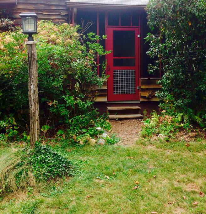 Entrance to screened in porch with locust log lamp post