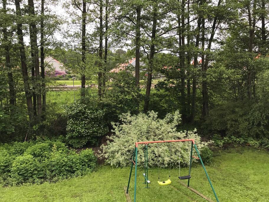 Längst nere vid tomten ringlar en bäck och på andra sidan fotbollsplan och lekyta