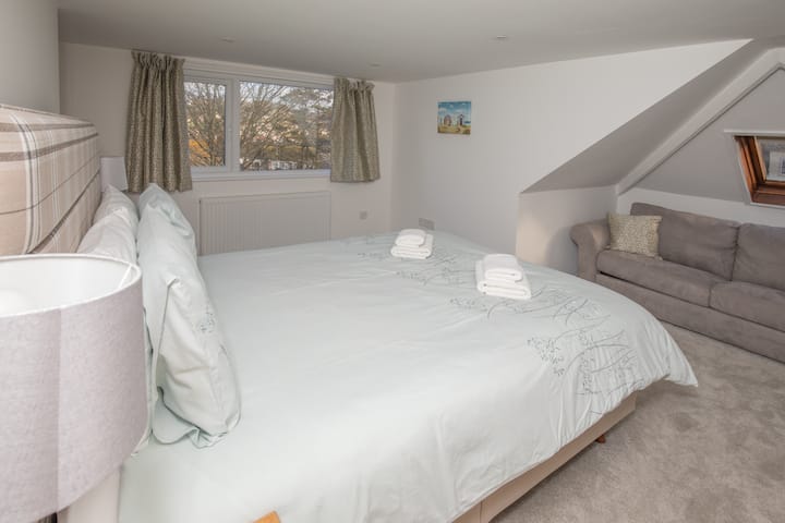 جناح مذهل في الطابق العلوي بسرير بحجم كبير وأريكة وغرفة نوم مبللة