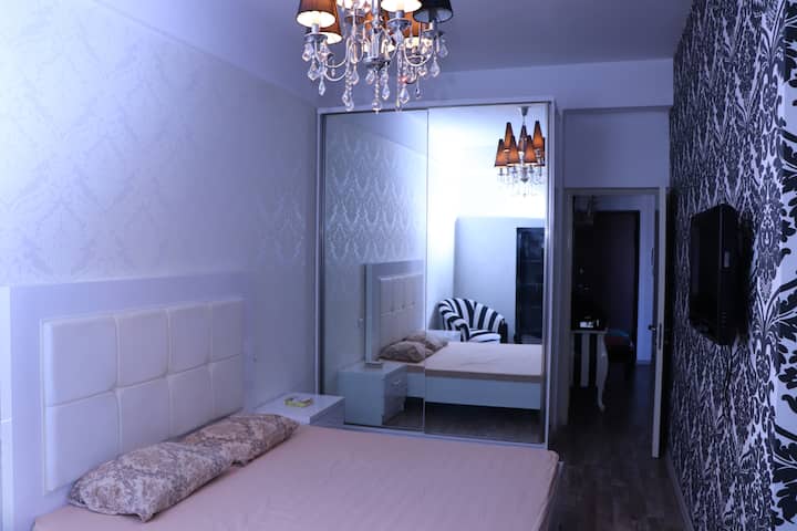 Moderna i elegantna spavaća soba opremljena je jednim bračnim krevetom i televizorom.