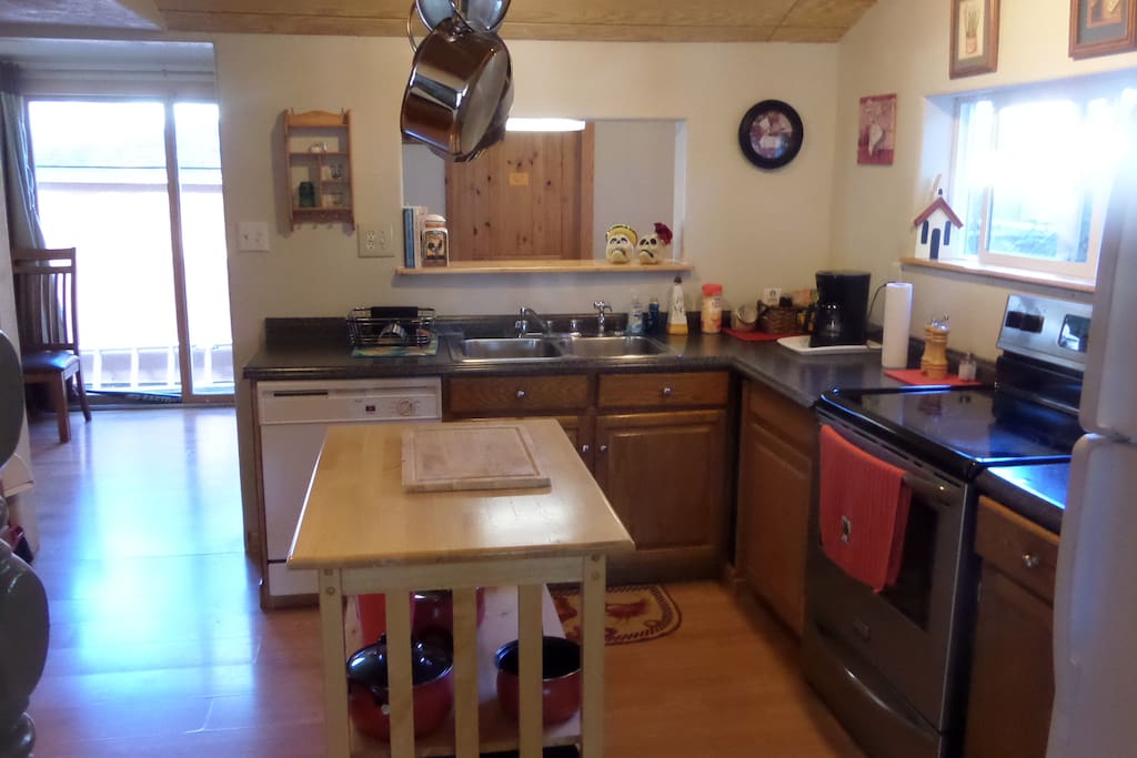 Kitchen with microwave, dishwasher, glass top range and full refrigerator with ice maker.