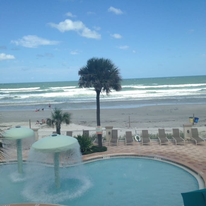View from condo's private balcony-direct oceanfront with 2 lounge chairs and side table