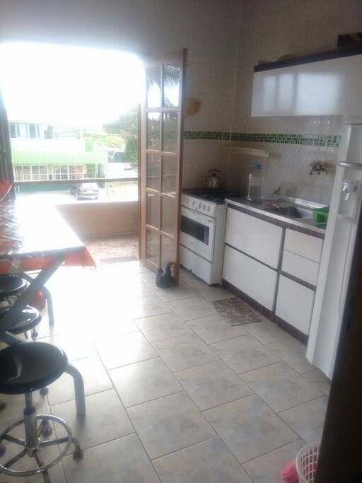 Cozinha com acesso a churrasqueira e varanda com bela vista