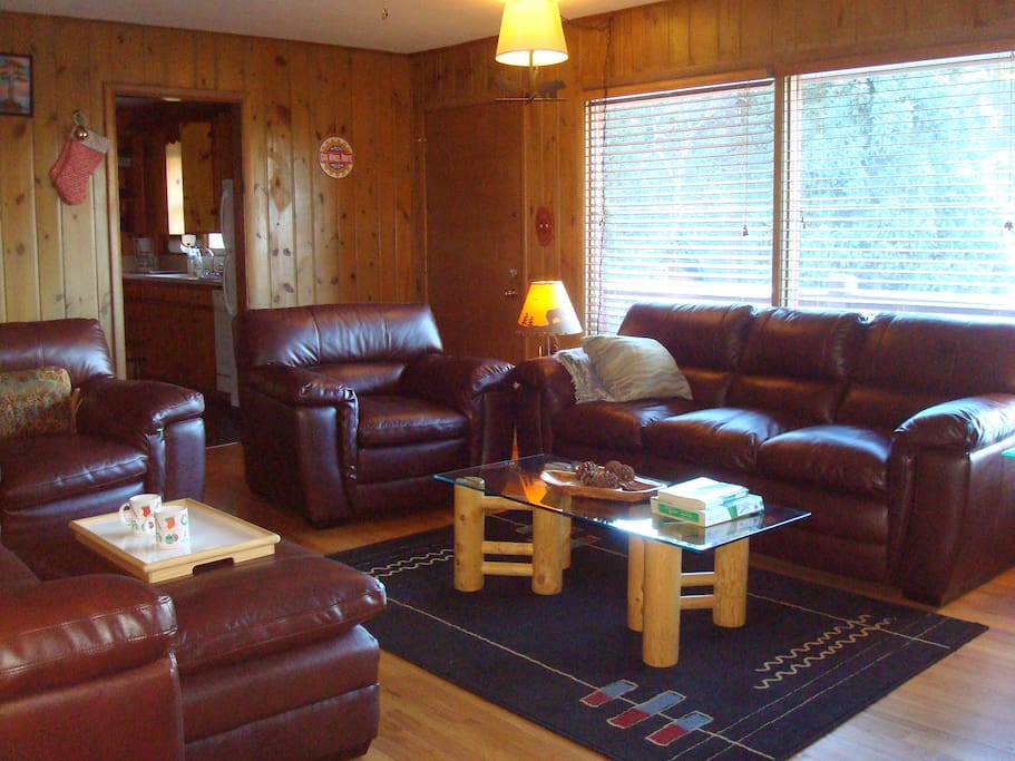 COZY LIVING ROOM HAS 2 SETS OF LEATHER FURNITURE PROVIDING COMFORTABLE SITTING FOR 8 PERSONS