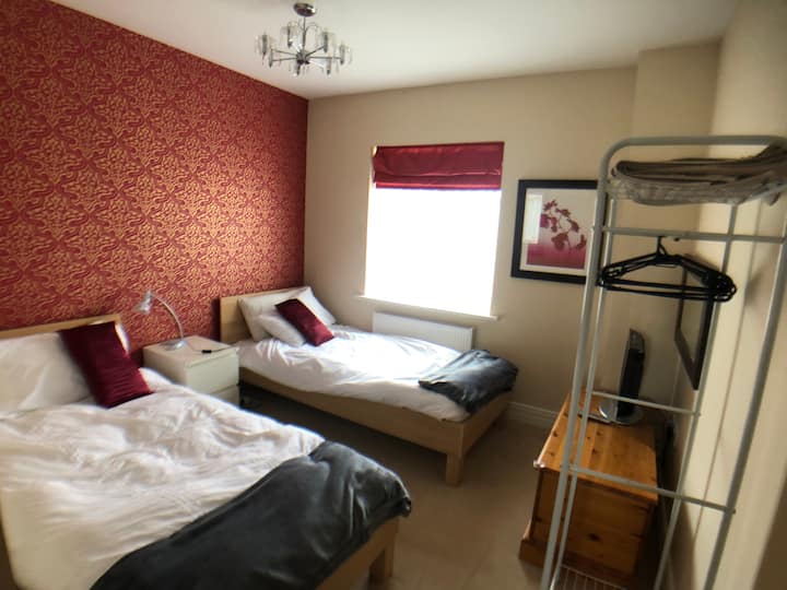 ห้องนอน 4 - เตียงแฝดพร้อมทีวีที่เก็บของและพื้นที่แขวน 